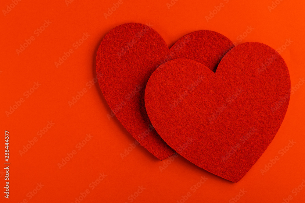 Obraz premium Two red felt heart on bright red background