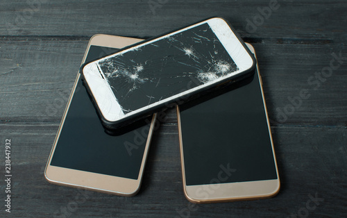 On a black background is a broken phone. Mobile gadget repair concept