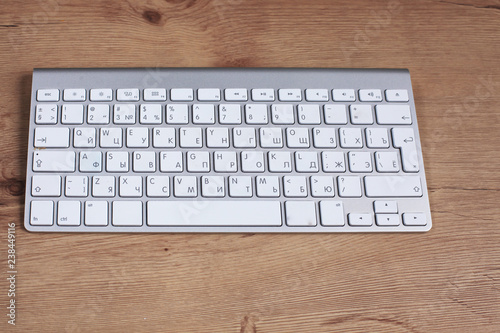 Modern aluminum keyboard on the wooden table in the office