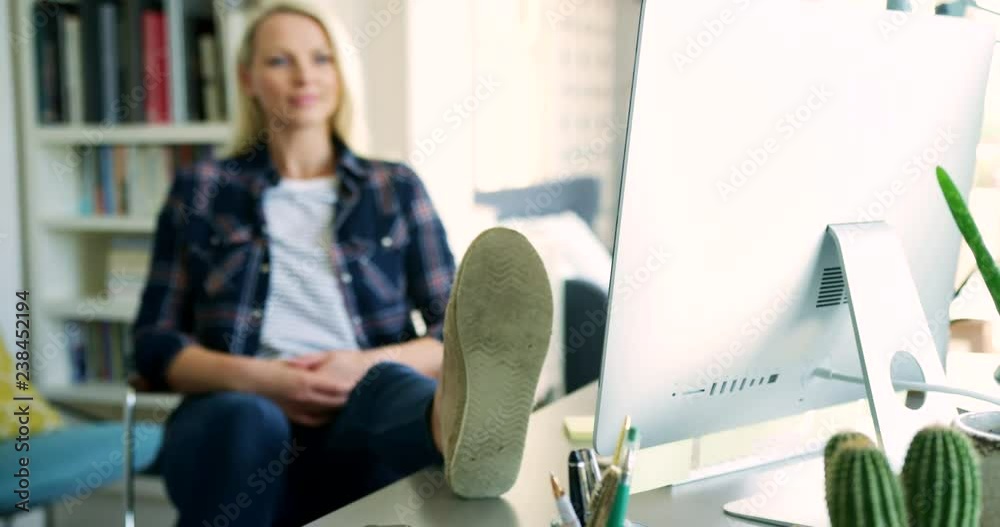 Attractive Blond Businesswoman Stretching And Relaxing At Her Desk