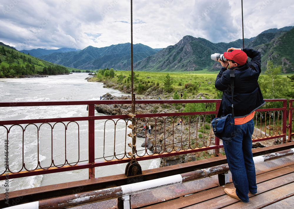 Man with camera near Katun River and Altai mountains Siberia