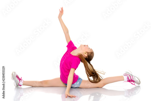 Girl gymnast perform the twine exercise.