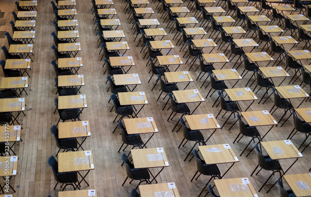 Examination hall set up with chairs and wooden desks 