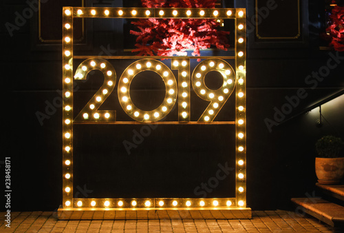 Installation new year  style background greeting  design. 2019 shape made with  glowing lamps and colorful blurs