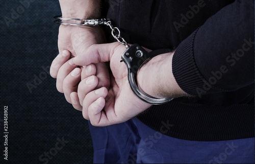 Arrested man in handcuffs hith hands behind back