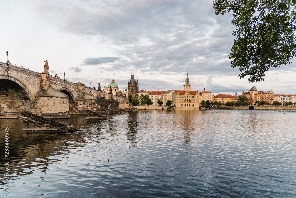 Charles Bridge over Vltava River against cloudy sky in city Charles Bridge over Vltava River against cloudy sky in city