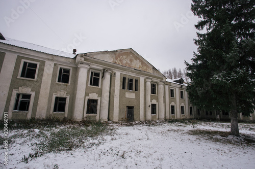 Ruined abandoned old mansion facade in winter