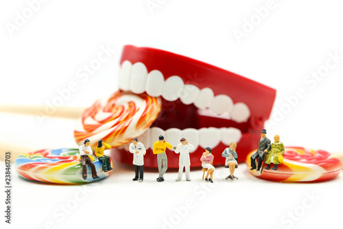 Miniature people : Dentist examining a patient's teeth with patient and sweet lollipops,healthcare medical concept.