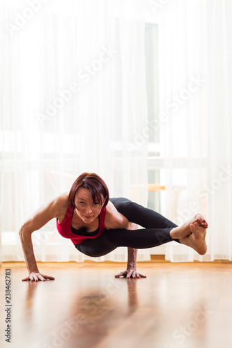 Yoga Concepts. Caucasian Woman Practicing Yoga Exercise Indoors At Bright Afternoon. Sitting in Ashtavakrasana Pose During Solitude Meditation Session.