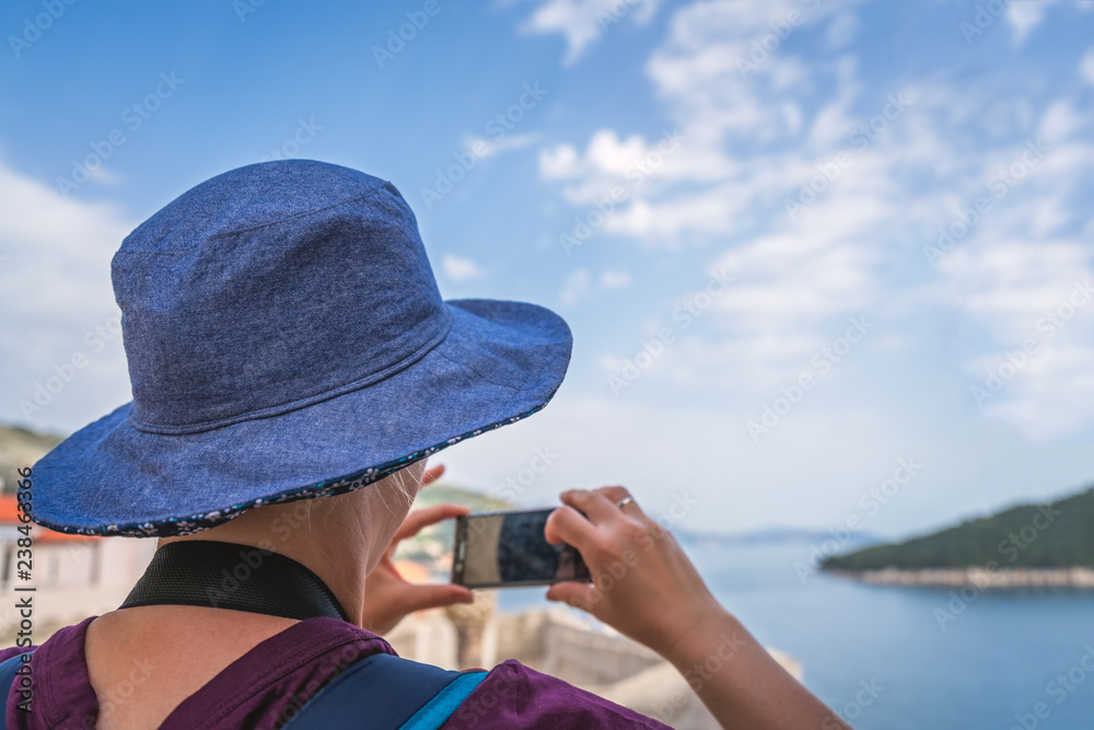 Female tourist taking pictures of Dubrovnik