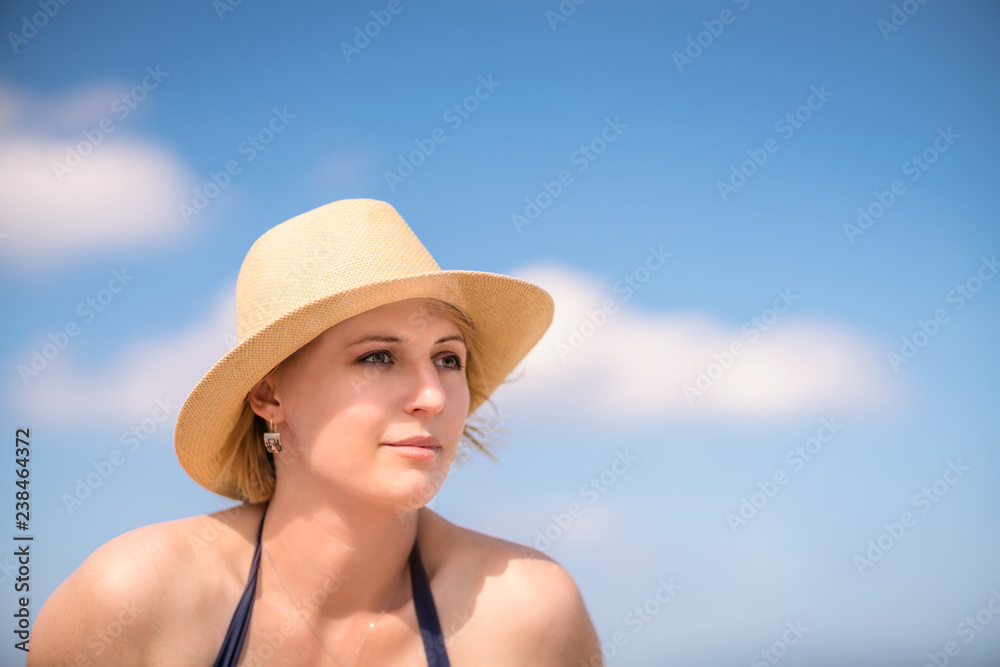 Beautiful Caucasian woman with a wicker white hat