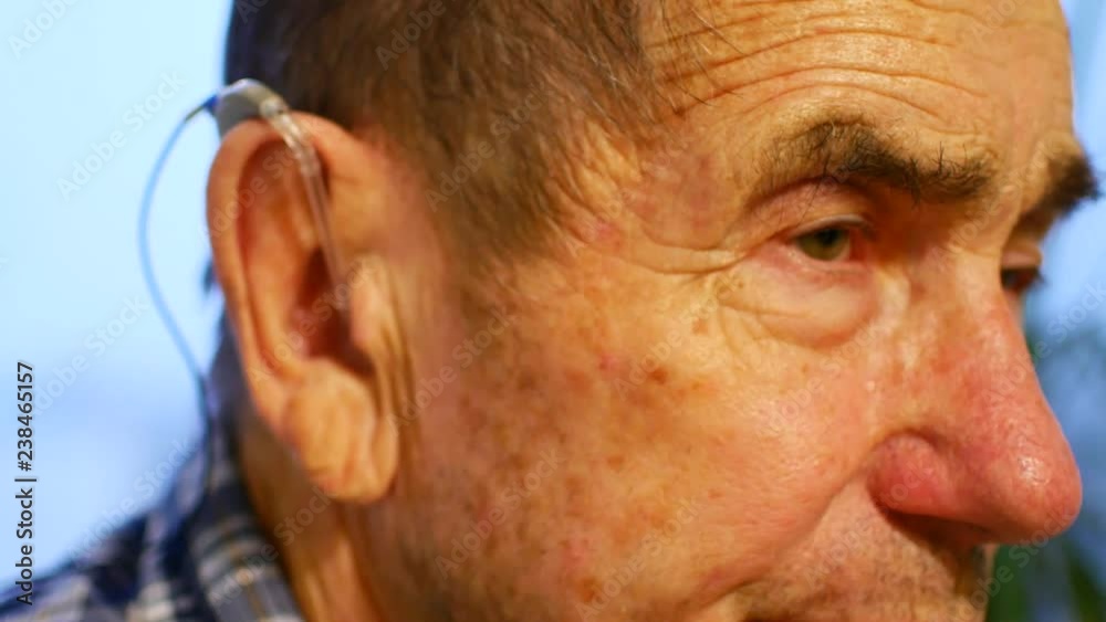 old man using hearing aids old man using hearing aids