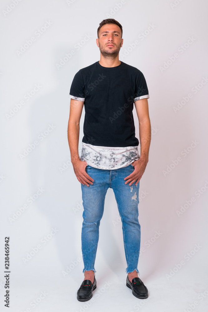 Obraz premium Full body shot of handsome bearded Persian man standing against white background