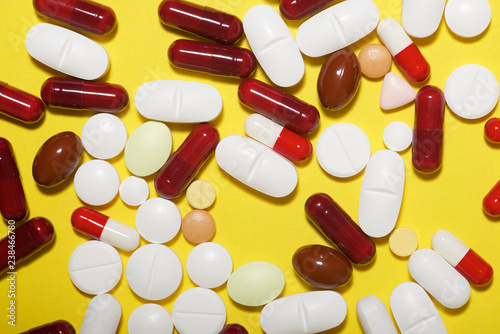 High angle view of various medicines over yellow background