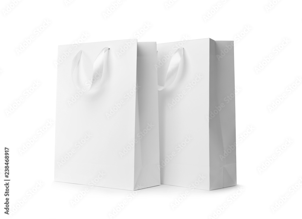 Paper shopping bags with ribbon handles on white background. Mockup for design Paper shopping bags with ribbon handles on white background. Mockup for design