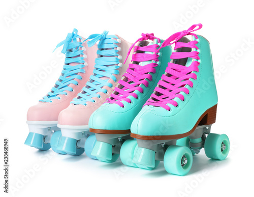 Pairs of bright stylish roller skates on white background
