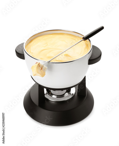 Pot of delicious cheese fondue and fork with bread on white background