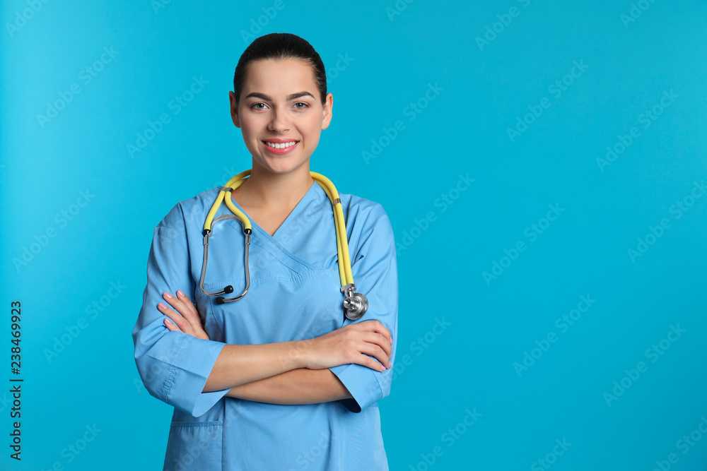 Portrait of young medical assistant with stethoscope on color background. Space for text Portrait of young medical assistant with stethoscope on color background. Space for text
