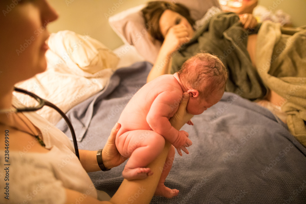 Midwife examining newborn baby in hospital Midwife examining newborn baby in hospital