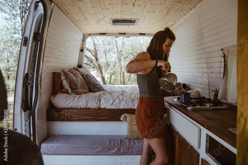 Side view of woman making drink in motorhome photo
