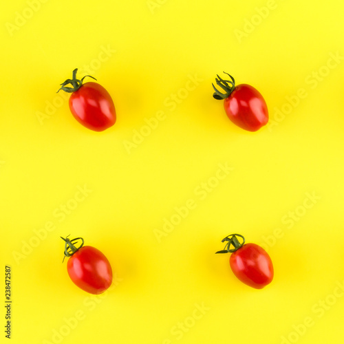 Food pattern of cherry tomato  isolated on yellow background. Flat lay, top view.