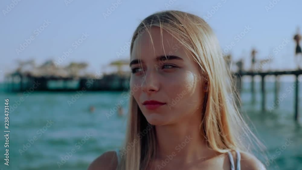 Portrait young blonde attractive woman look at camera near sea relax holiday paradise swimwear travel beautiful sunlight water enjoying beach adult beauty girl slow motion Portrait young blonde attractive woman look at camera near sea relax holiday paradise swimwear travel beautiful sunlight water enjoying beach adult beauty girl slow motion