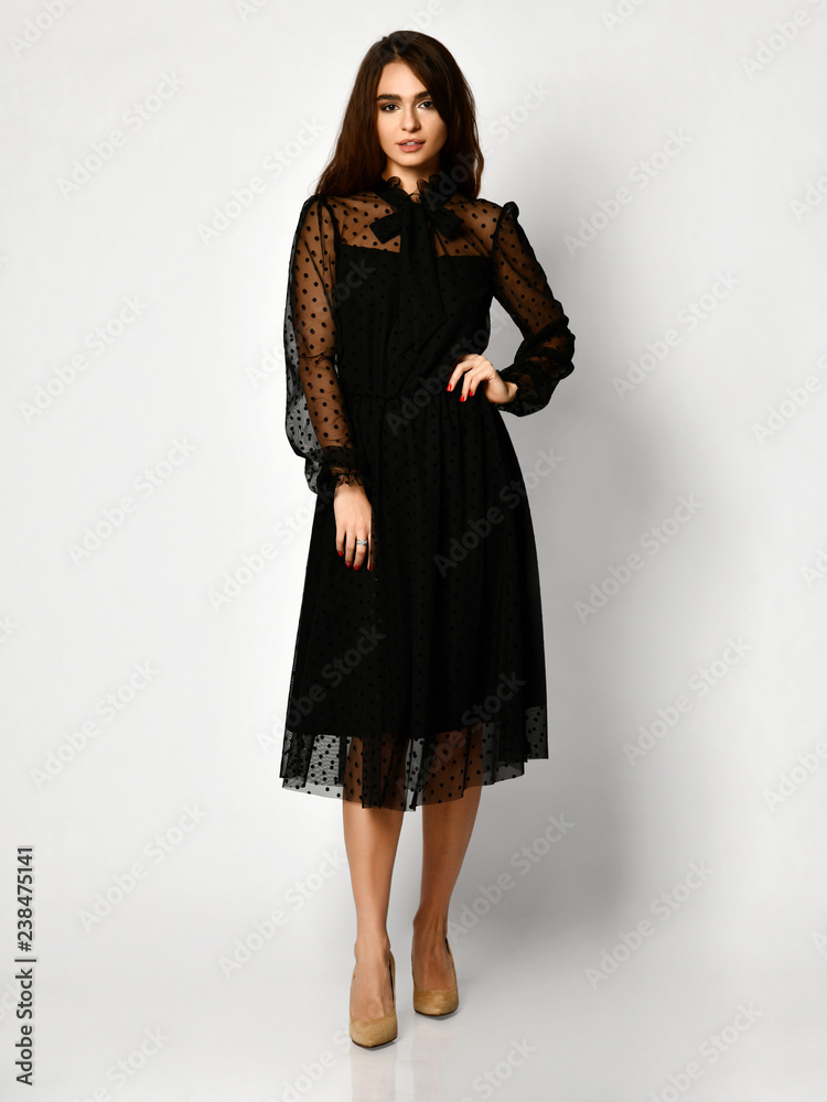 Young beautiful woman posing in new black fashion winter dress full body on a white Young beautiful woman posing in new black fashion winter dress full body on a white