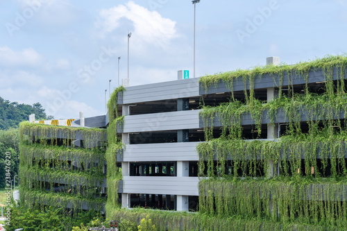 Modern parking garage building covered with plant, exterior decoration.