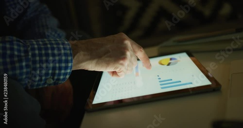 Businessman Working Late Analyzing Financial Graphs On Digital Tablet At Home 4K