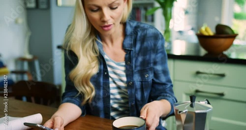 Beautiful Blond Woman Checking Smart Phone While Drinking Coffee