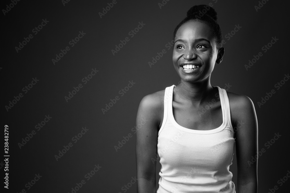 Young beautiful African Zulu woman smiling and thinking in black and white