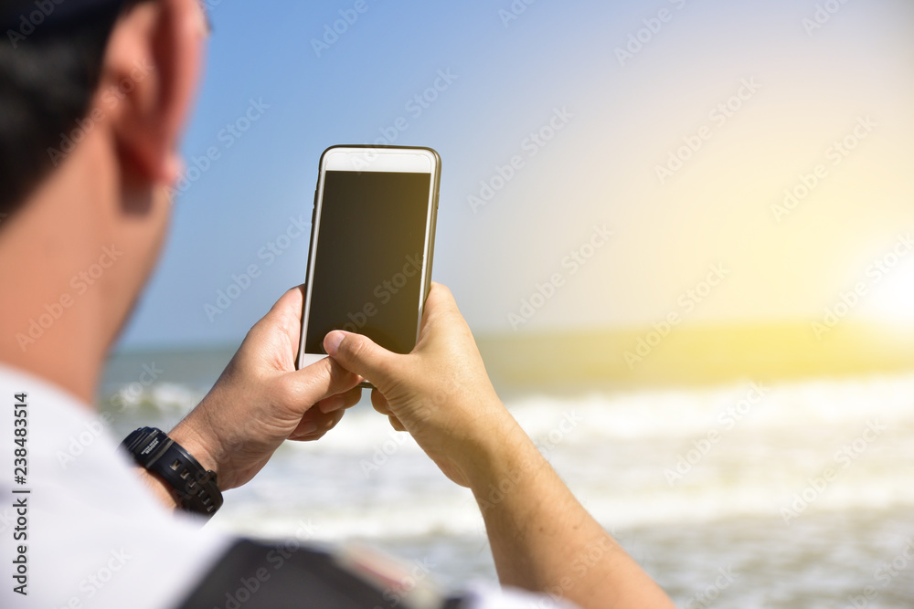 People are holding mobile smart phone at sea  background
