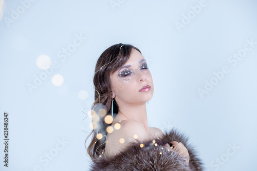 Portrait of woman with artistic make-up isolated on white background.cute face of young woman with creative make up and closed eyes.Creative Winter Holiday Makeup.glitter lips,face design and manicure