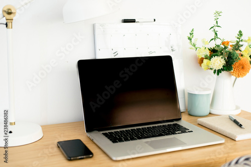 High angle view of technologies with calendar and desk lamp by flower vase on wooden table in office photo