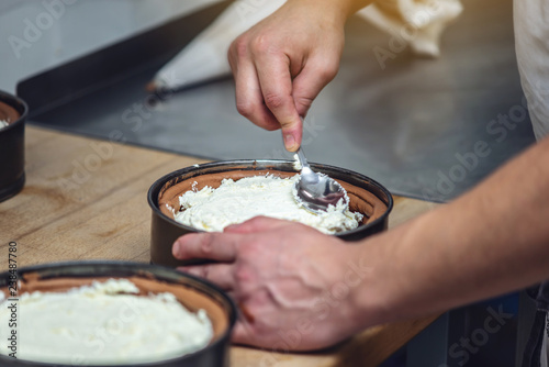 Pastry chef fills the cream filling for the cake. Production of confectionery