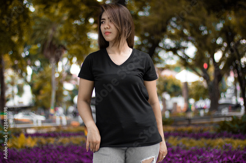 Young woman wearing black v neck t-shirt posing at park photo
