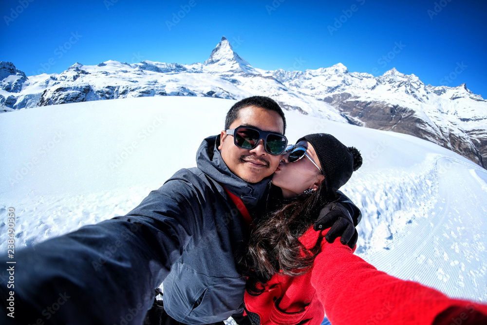 Young sweet couple taking selfie with the view of Matterhorn Mountain, Zermatt, Switzerland