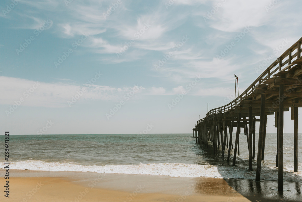 Pier over sea against sky during sunny day Pier over sea against sky during sunny day