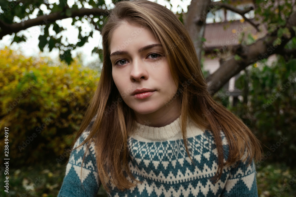 Portrait of young woman with blond hair sitting in backyard Portrait of young woman with blond hair sitting in backyard