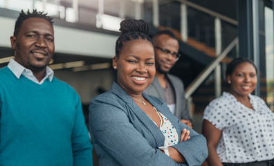 Portrait of a confident black businesswoman with all african american team in the background