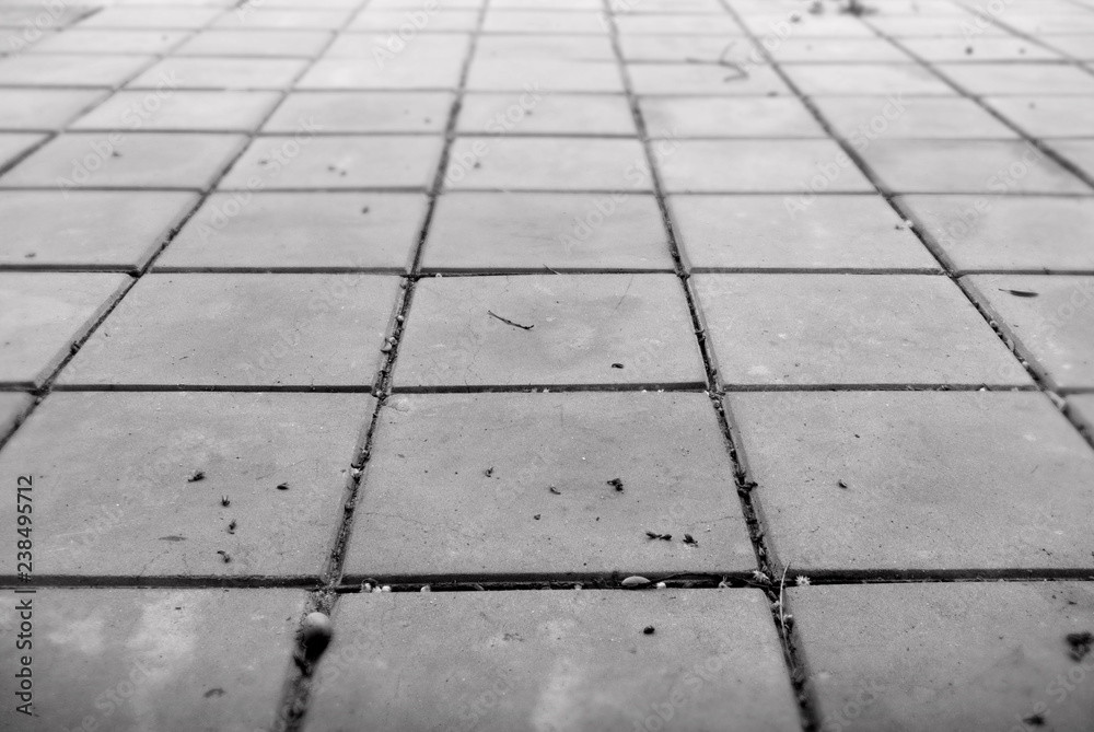 Close-up image perspective view of gray brick stone on the ground, gray pavement square pattern, monochrome and horizontal image.