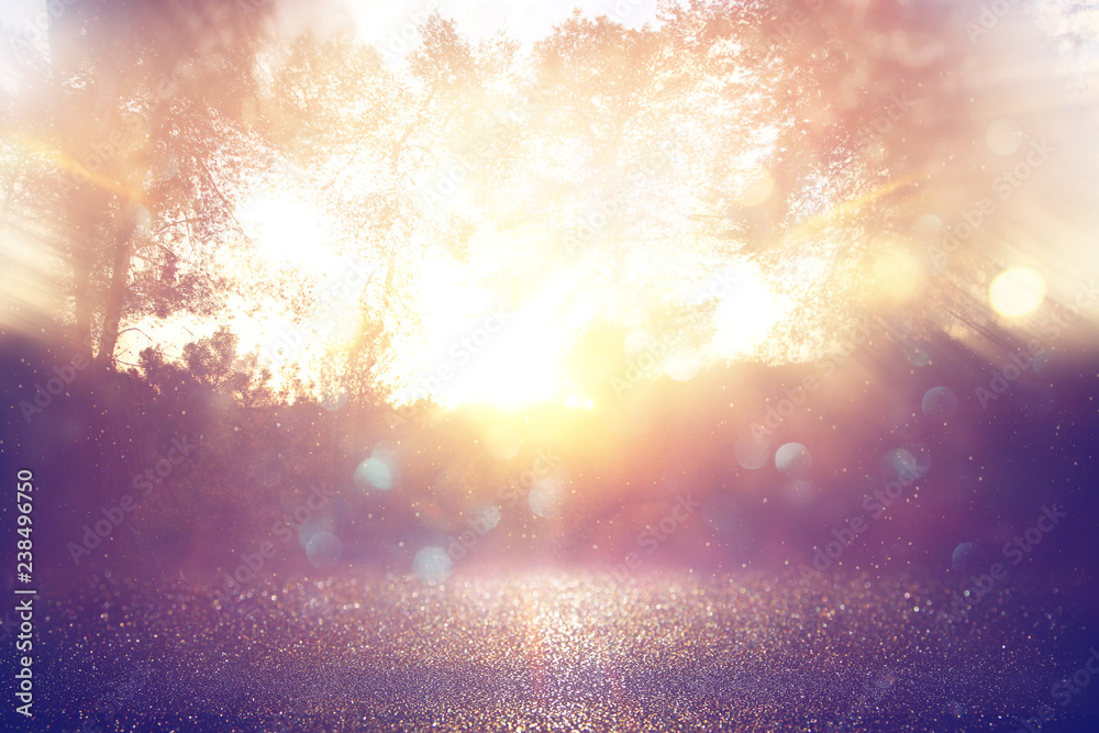 blurred abstract photo of light burst among trees and glitter golden bokeh lights. blurred abstract photo of light burst among trees and glitter golden bokeh lights.