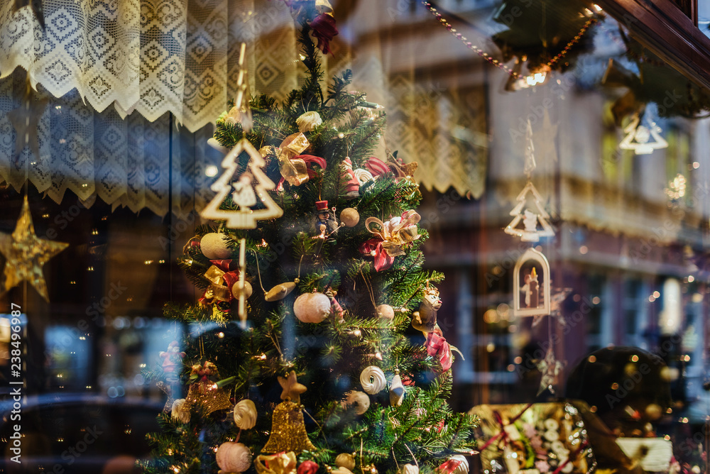 Vienna, Austria - December 21, 2017. Showcase with christmas tree decoration and lighting garlands by wintertime. Glass display with xmas ornaments and lights.