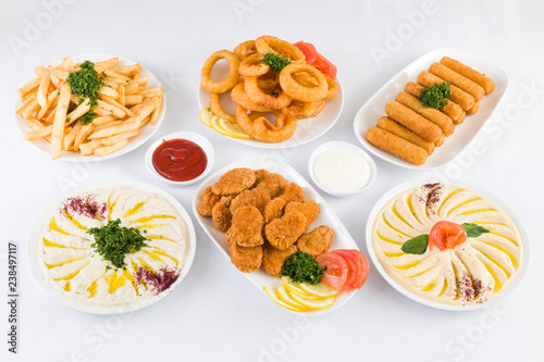 Wallpaper Mural French Fries, Onion Rings, Mozzarella Cheese Sticks, Chicken Nuggets, Hummus and Baba ghanoush on the  table Torontodigital.ca