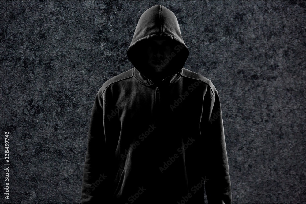 Dark unrecognisable man in hoodie on background Dark unrecognisable man in hoodie on background