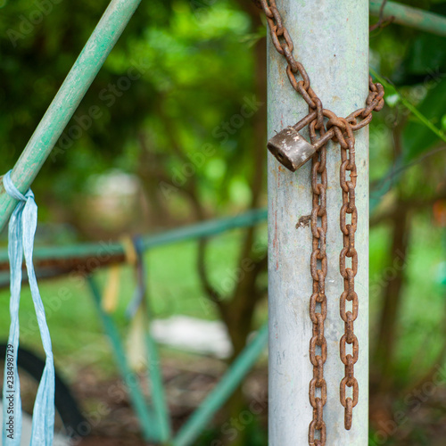 Closeup Closeup picture of rusted lock and chain on the steel column with blurred bokeh bpicture of rusted lock and chain on the steel column with blurred bokeh background. Love and commitment concept photo