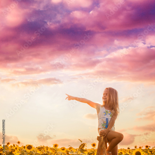 The girl looks around the sunflower field