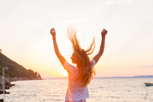 A beautyful woman feeling free meeting sun near the sea