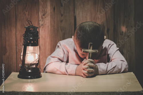 Boy hands holding a holy cross and praying to God, Child Praying for God Religion.