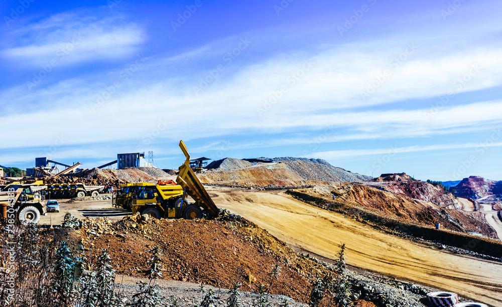 View of opencast mining quarry with lots of machinery at work
